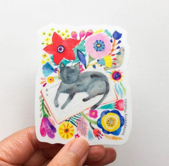 Black Cat Napping on a Book Sticker by Honeyberry Studios